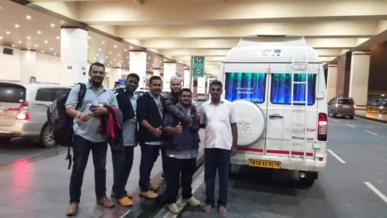 Group of travellers beside a Tempo Traveller